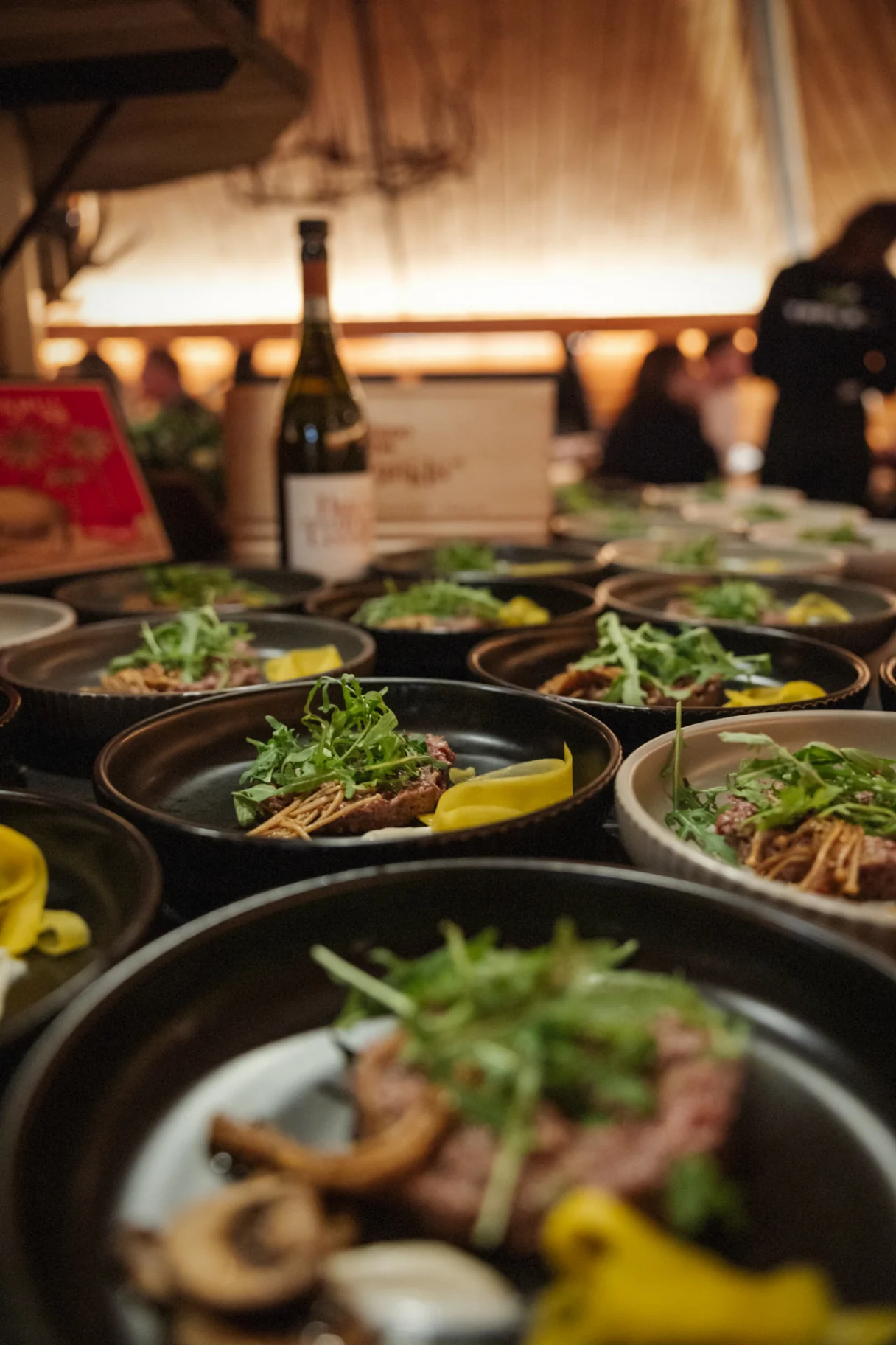 Beef tartare with arugula plated for a long table