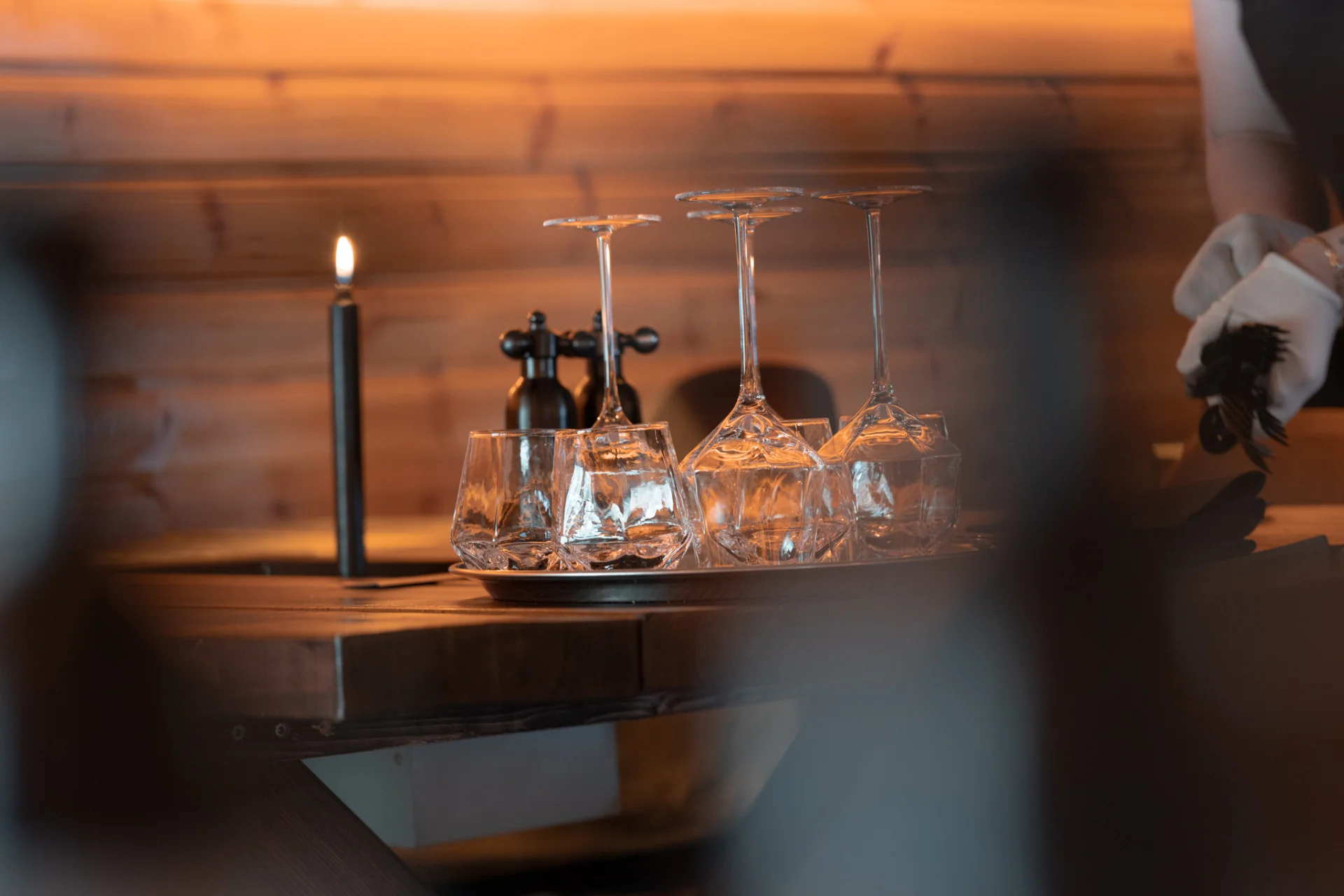Wine glasses and candlelight on the wooden bar