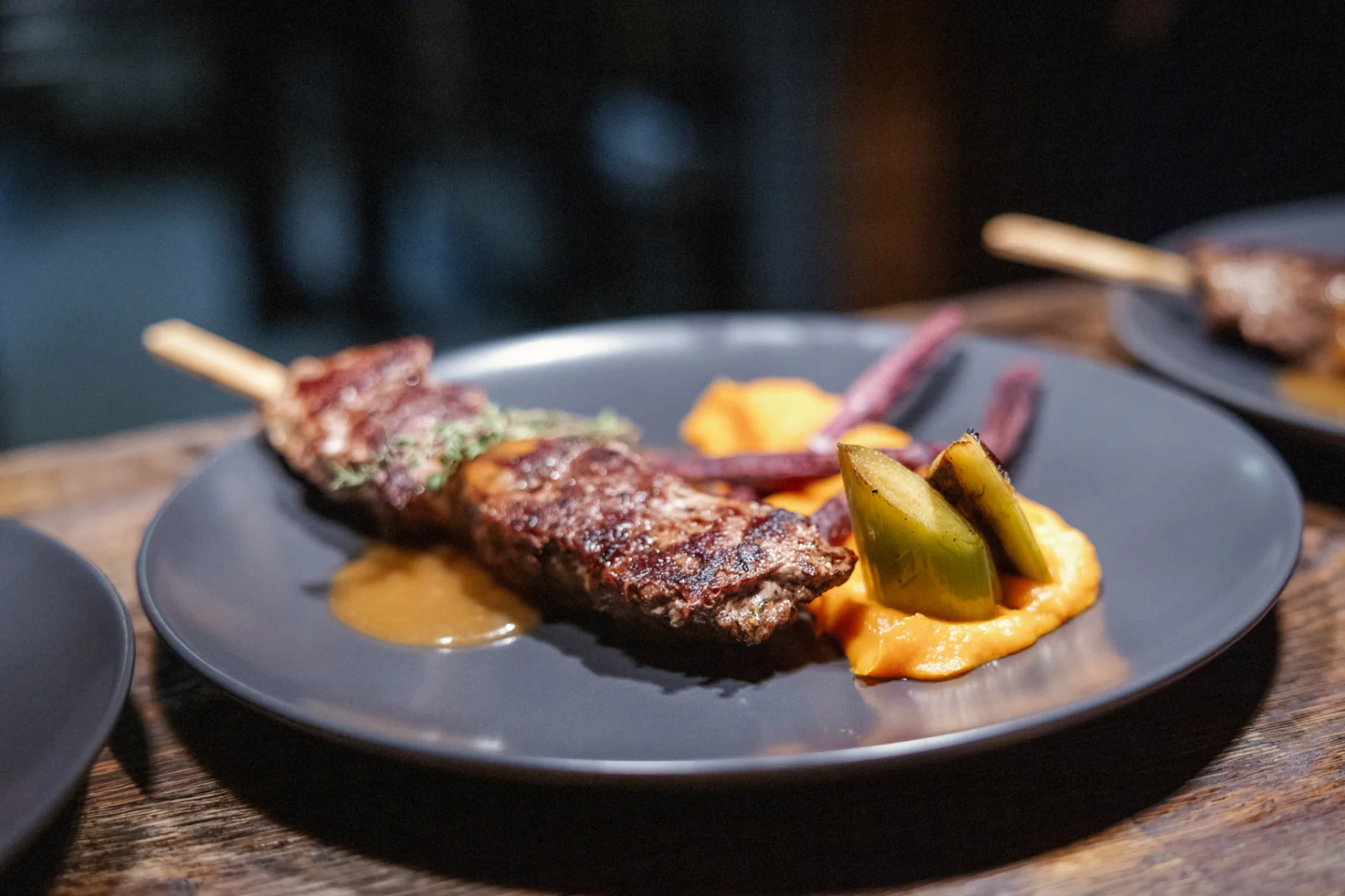 Grilled beef skewer with carrot purée and heritage vegetables